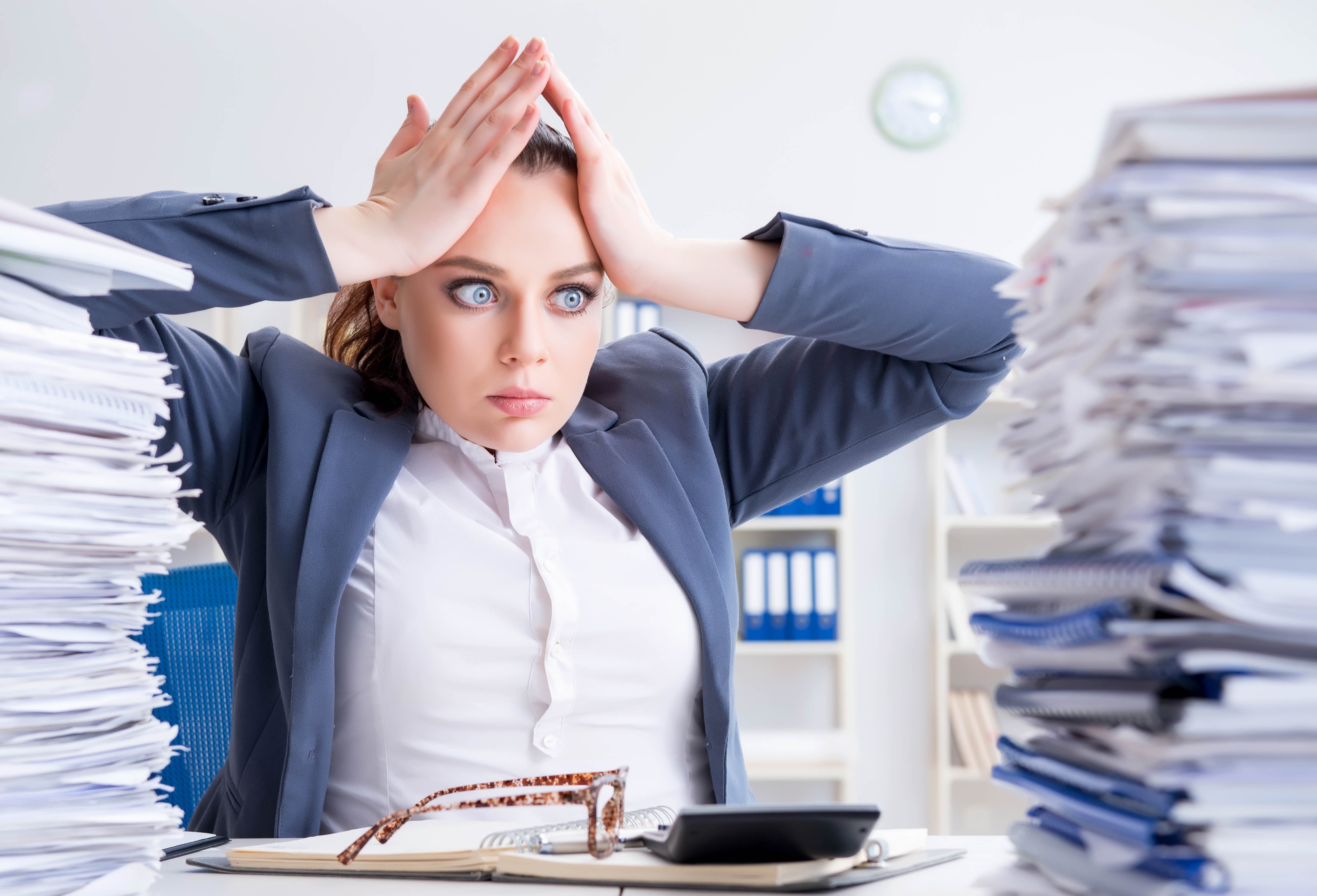 Woman feeling overwhelmed by paperwork